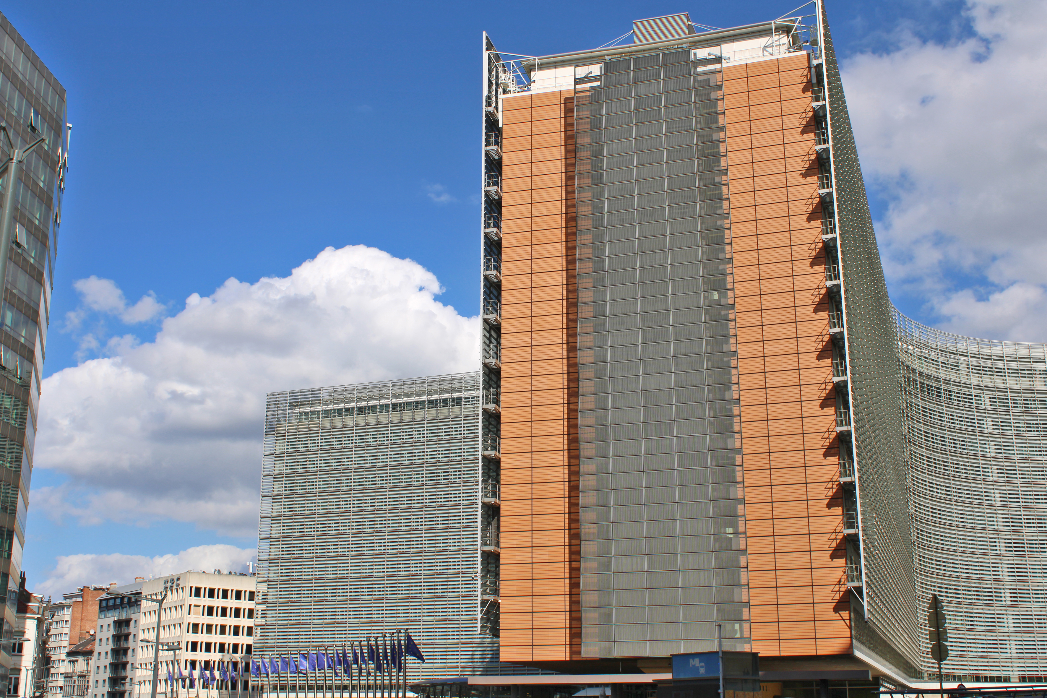 Decorative photo of the EU institutions headquarters in Brussels, place Schuman. It shows EU flags and the Berlaymont building of the European Commission on a sunny day in September 2026